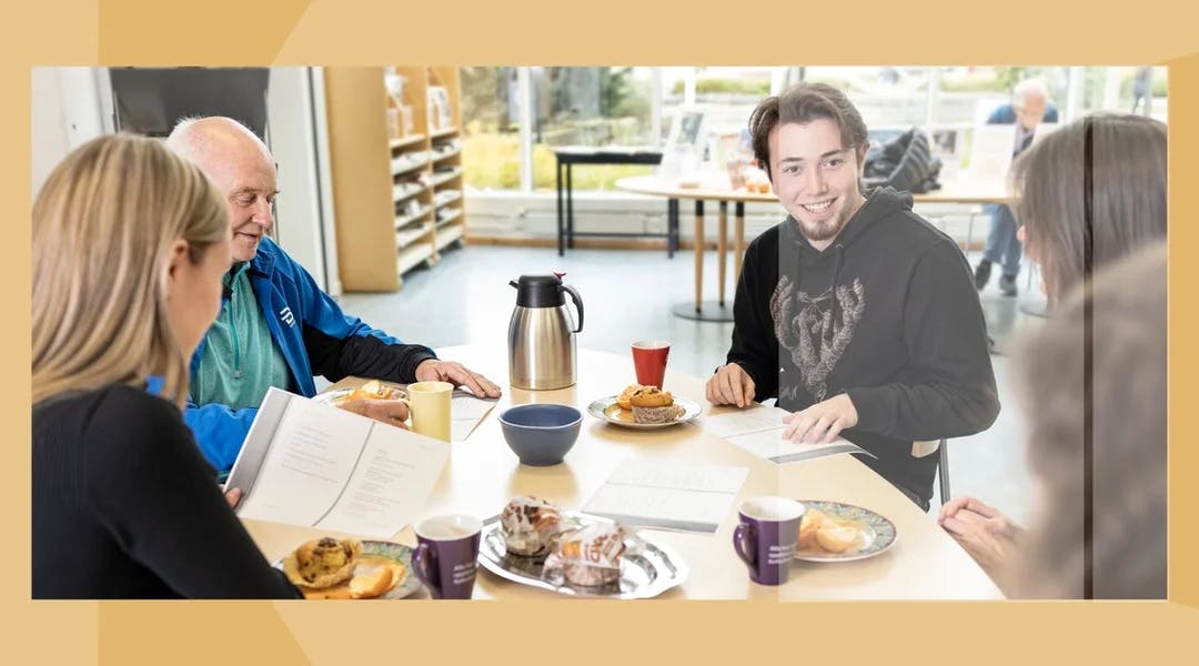 Fem personer sitter rundt et bord. På bordet er det ark, kaffe, muffins og appelsin.